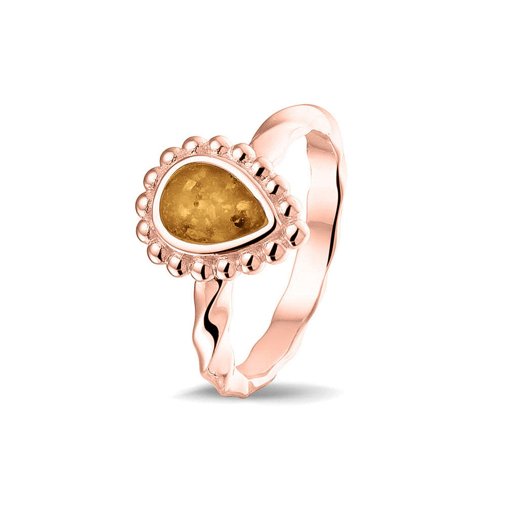 Gedenksieraad, asring met gedraaide scheen waar aan de bovenzijde in druppelvorm met parelrand zichtbaar as of haar (of eventueel melktandjes of moedermelk) verwerkt wordt.gold