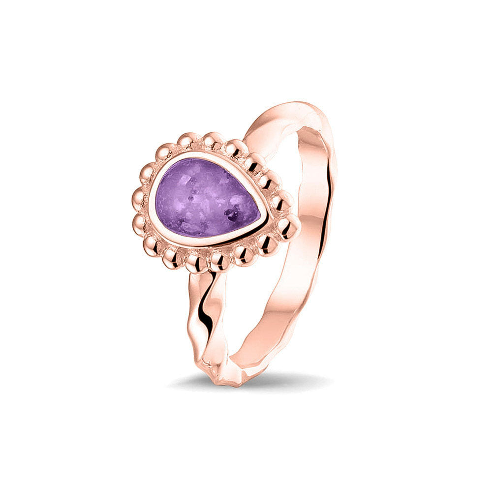 Gedenksieraad, asring met gedraaide scheen waar aan de bovenzijde in druppelvorm met parelrand zichtbaar as of haar (of eventueel melktandjes of moedermelk) verwerkt wordt.purple