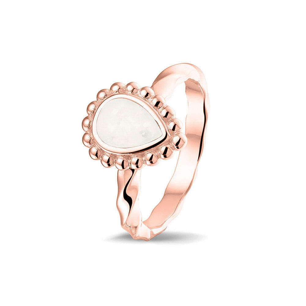 Gedenksieraad, asring met gedraaide scheen waar aan de bovenzijde in druppelvorm met parelrand zichtbaar as of haar (of eventueel melktandjes of moedermelk) verwerkt wordt.white