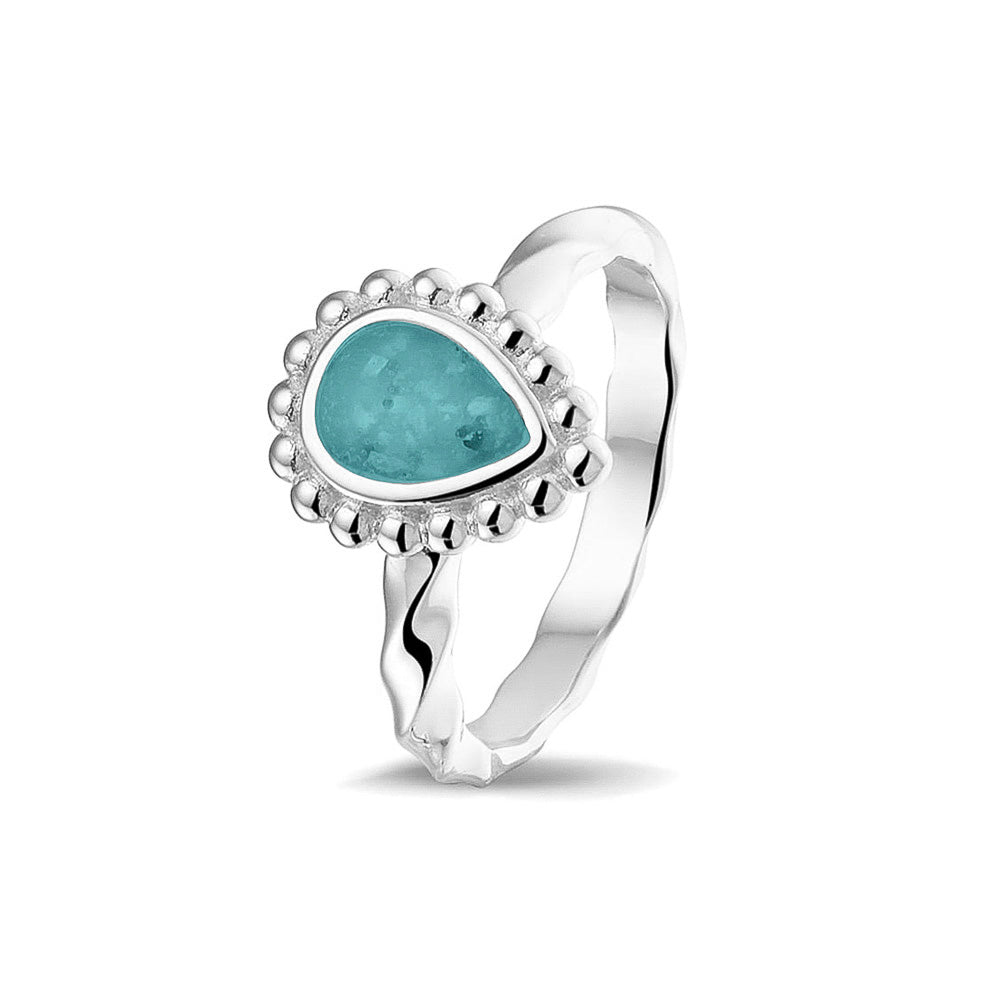 Gedenksieraad, asring met gedraaide scheen waar aan de bovenzijde in druppelvorm met parelrand zichtbaar as of haar (of eventueel melktandjes of moedermelk) verwerkt wordt.aqua