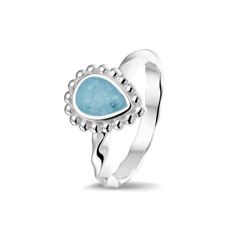 Gedenksieraad, asring met gedraaide scheen waar aan de bovenzijde in druppelvorm met parelrand zichtbaar as of haar (of eventueel melktandjes of moedermelk) verwerkt wordt.baby