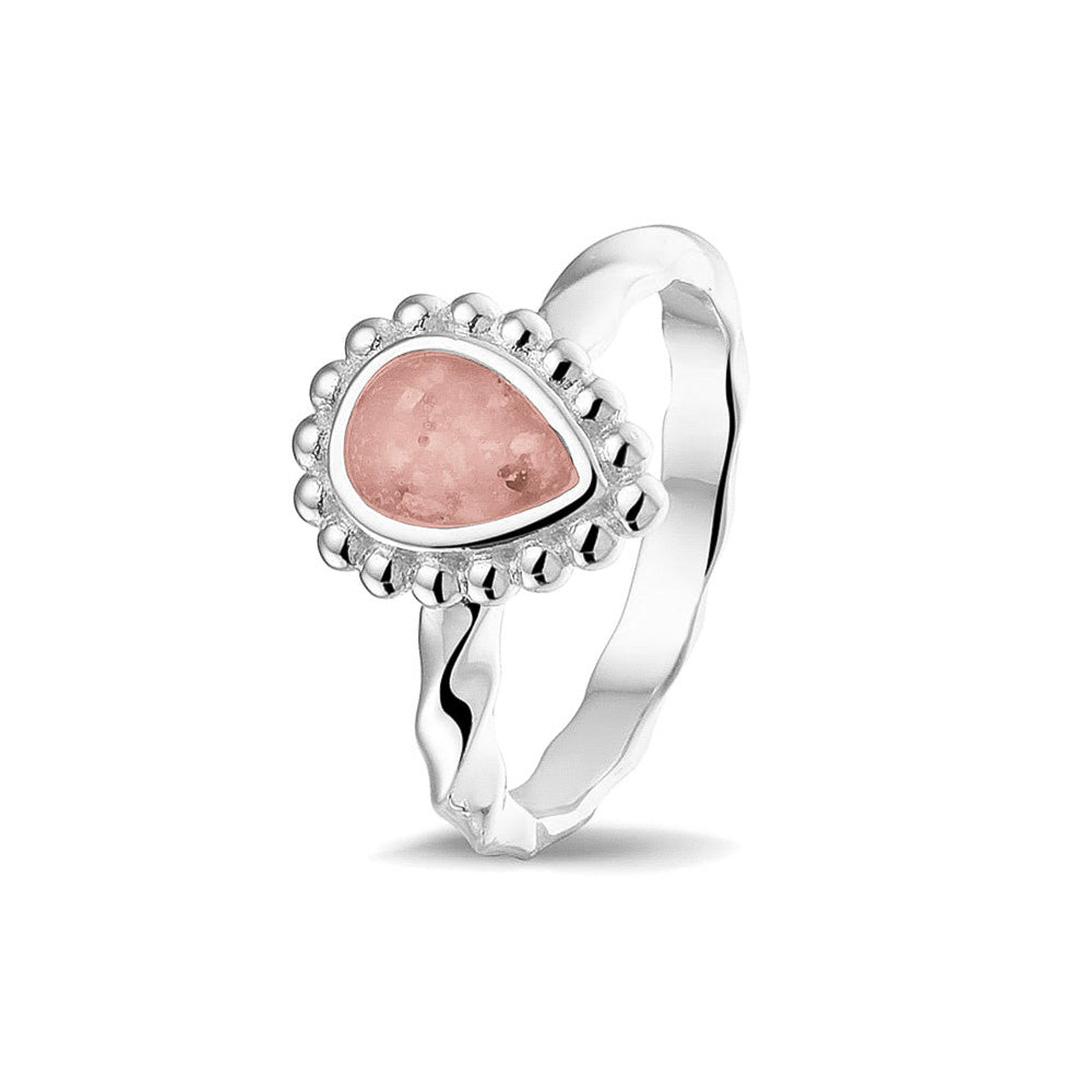 Gedenksieraad, asring met gedraaide scheen waar aan de bovenzijde in druppelvorm met parelrand zichtbaar as of haar (of eventueel melktandjes of moedermelk) verwerkt wordt.blush