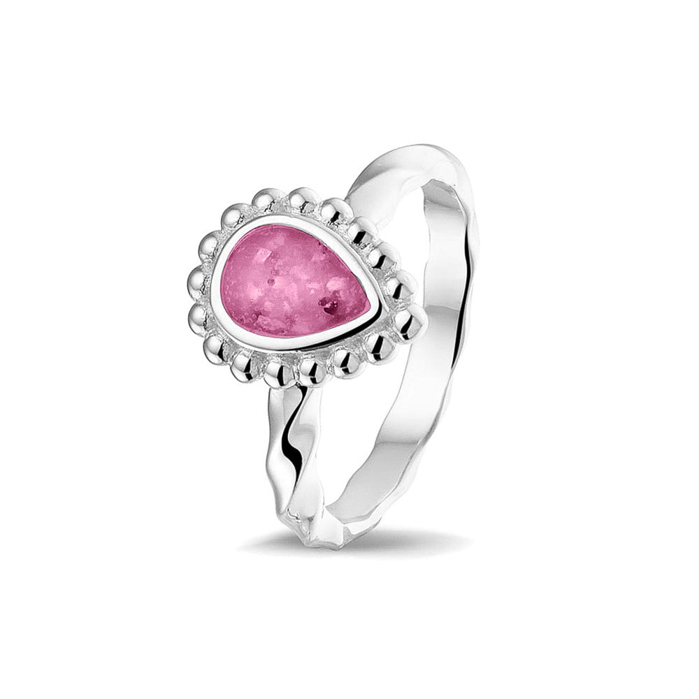 Gedenksieraad, asring met gedraaide scheen waar aan de bovenzijde in druppelvorm met parelrand zichtbaar as of haar (of eventueel melktandjes of moedermelk) verwerkt wordt.fluo