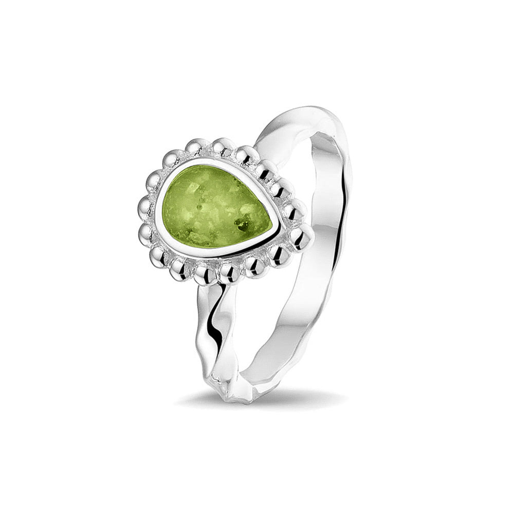 Gedenksieraad, asring met gedraaide scheen waar aan de bovenzijde in druppelvorm met parelrand zichtbaar as of haar (of eventueel melktandjes of moedermelk) verwerkt wordt.green