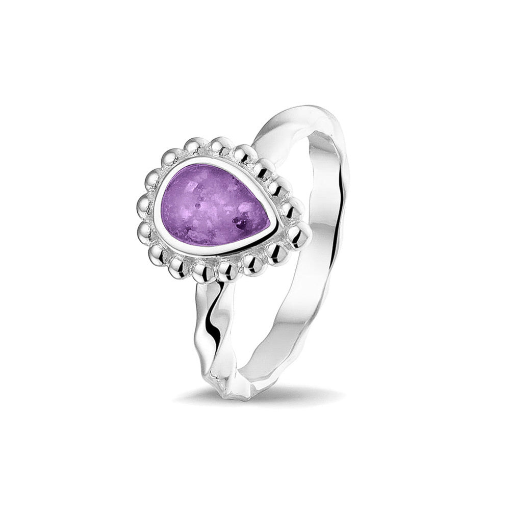 Gedenksieraad, asring met gedraaide scheen waar aan de bovenzijde in druppelvorm met parelrand zichtbaar as of haar (of eventueel melktandjes of moedermelk) verwerkt wordt.purple