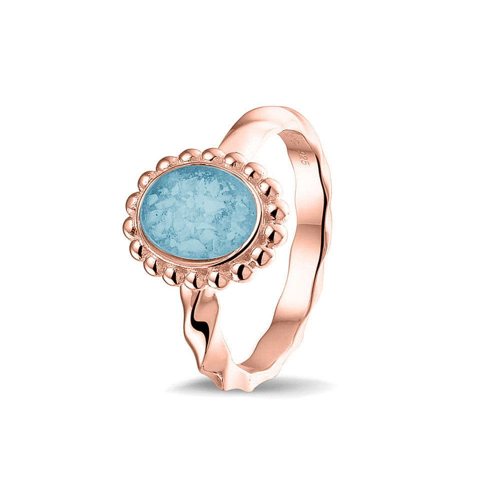 Gedenksieraad, asring met gedraaide scheen waar aan de bovenzijde in druppelvorm met parelrand zichtbaar as of haar (of eventueel melktandjes of moedermelk) verwerkt wordt. Baby