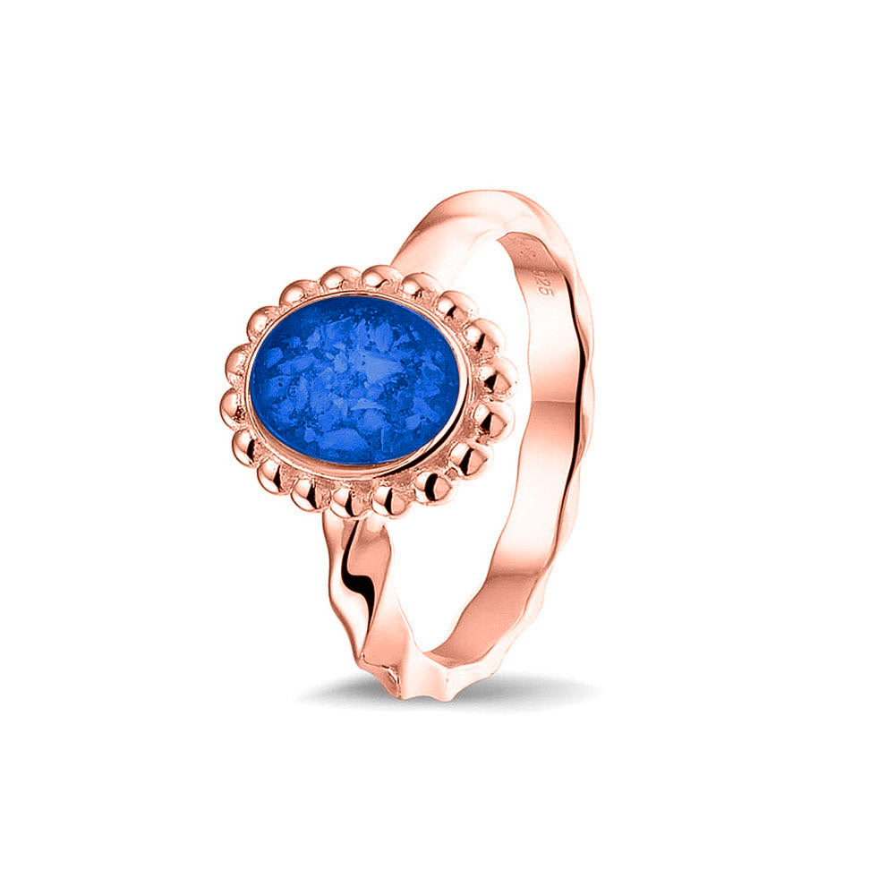 Gedenksieraad, asring met gedraaide scheen waar aan de bovenzijde in druppelvorm met parelrand zichtbaar as of haar (of eventueel melktandjes of moedermelk) verwerkt wordt. Blue