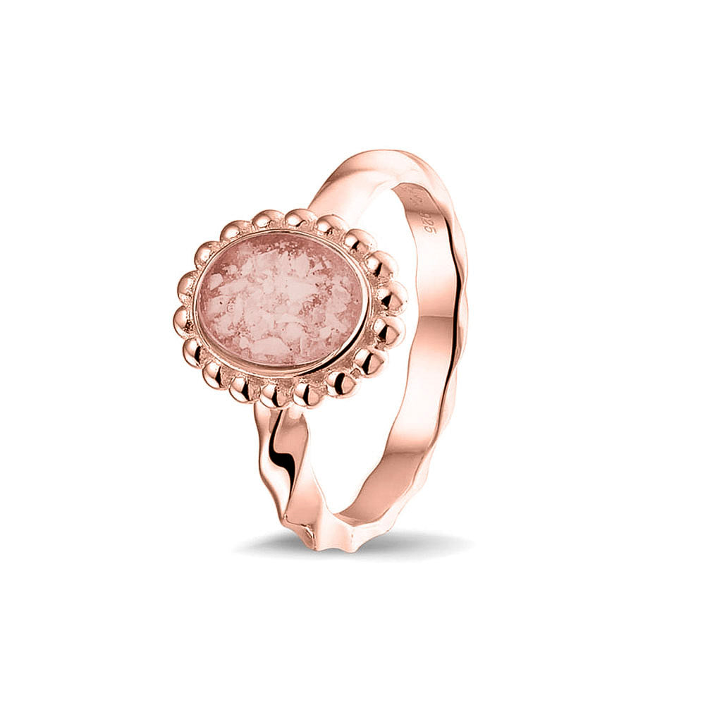 Gedenksieraad, asring met gedraaide scheen waar aan de bovenzijde in druppelvorm met parelrand zichtbaar as of haar (of eventueel melktandjes of moedermelk) verwerkt wordt. Blush