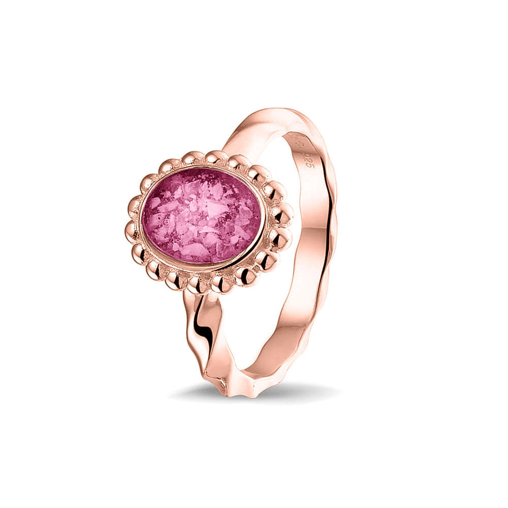 Gedenksieraad, asring met gedraaide scheen waar aan de bovenzijde in druppelvorm met parelrand zichtbaar as of haar (of eventueel melktandjes of moedermelk) verwerkt wordt. Fluo