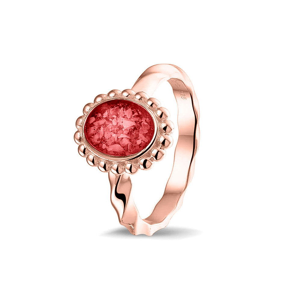 Gedenksieraad, asring met gedraaide scheen waar aan de bovenzijde in druppelvorm met parelrand zichtbaar as of haar (of eventueel melktandjes of moedermelk) verwerkt wordt. Red