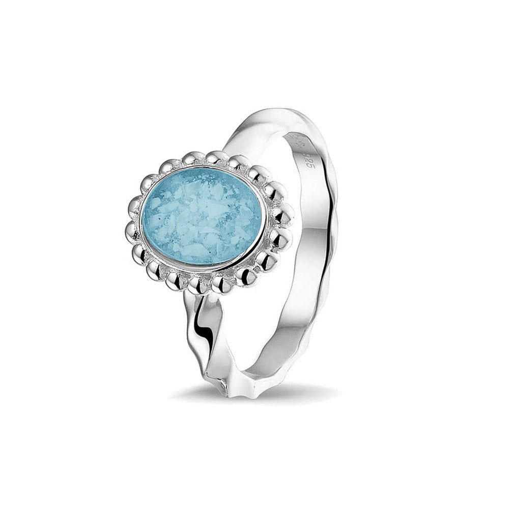 Gedenksieraad, asring met gedraaide scheen waar aan de bovenzijde in druppelvorm met parelrand zichtbaar as of haar (of eventueel melktandjes of moedermelk) verwerkt wordt. Baby