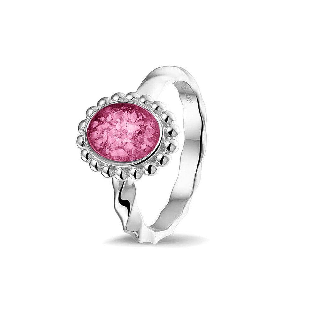 Gedenksieraad, asring met gedraaide scheen waar aan de bovenzijde in druppelvorm met parelrand zichtbaar as of haar (of eventueel melktandjes of moedermelk) verwerkt wordt. Fluo