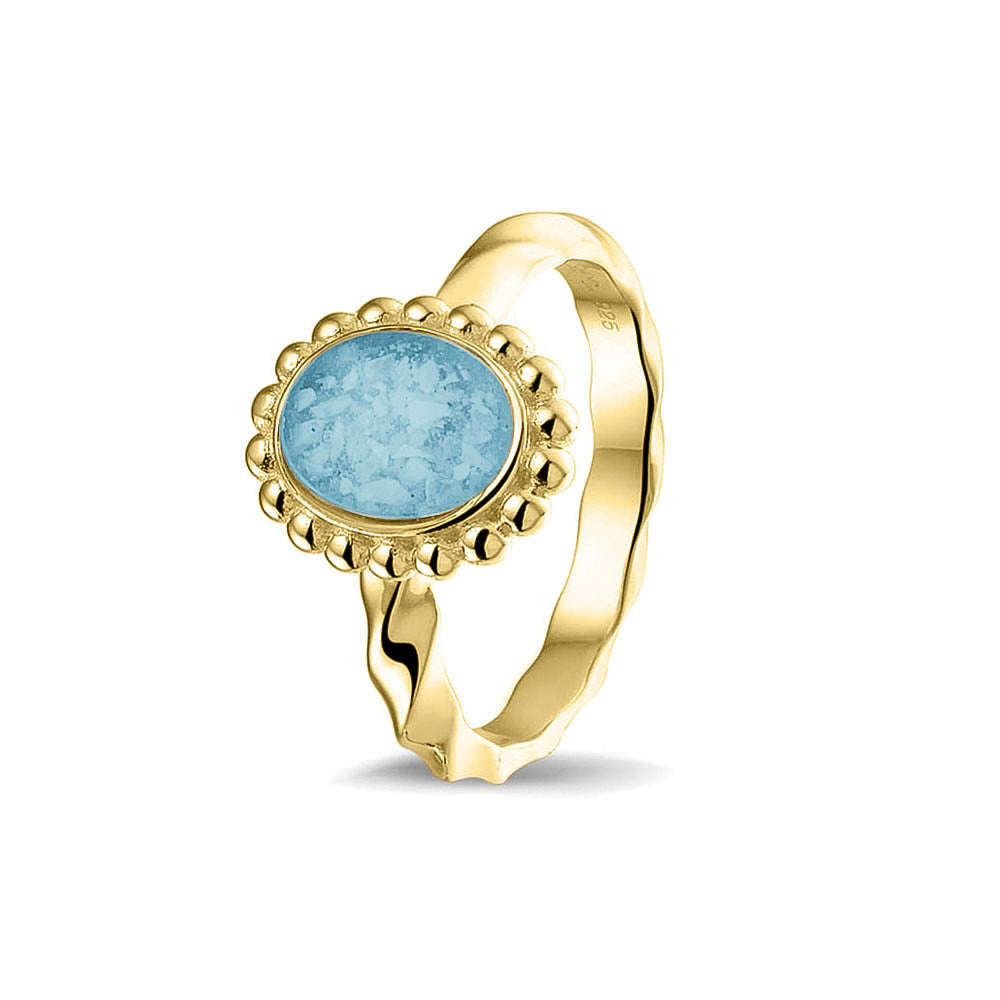 Gedenksieraad, asring met gedraaide scheen waar aan de bovenzijde in druppelvorm met parelrand zichtbaar as of haar (of eventueel melktandjes of moedermelk) verwerkt wordt. Baby