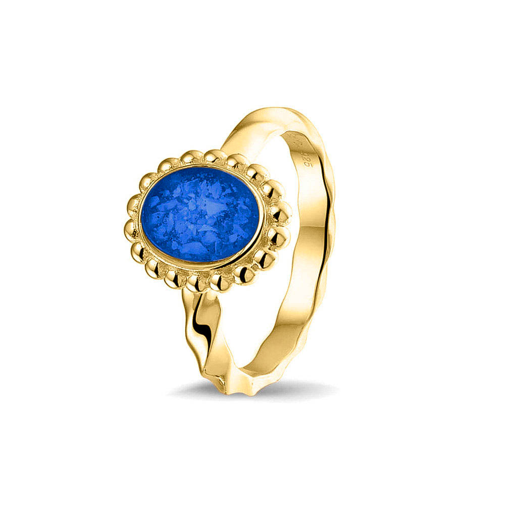 Gedenksieraad, asring met gedraaide scheen waar aan de bovenzijde in druppelvorm met parelrand zichtbaar as of haar (of eventueel melktandjes of moedermelk) verwerkt wordt. Blue