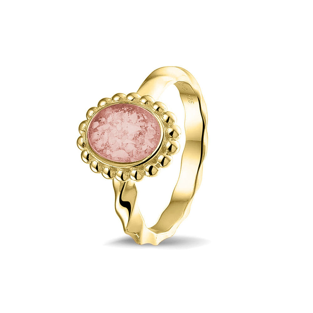 Gedenksieraad, asring met gedraaide scheen waar aan de bovenzijde in druppelvorm met parelrand zichtbaar as of haar (of eventueel melktandjes of moedermelk) verwerkt wordt. Blush