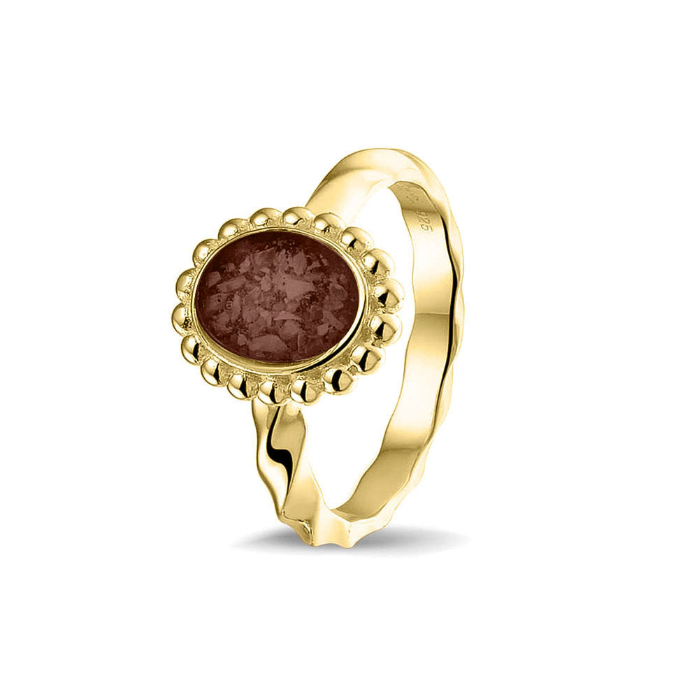 Gedenksieraad, asring met gedraaide scheen waar aan de bovenzijde in druppelvorm met parelrand zichtbaar as of haar (of eventueel melktandjes of moedermelk) verwerkt wordt. Brown