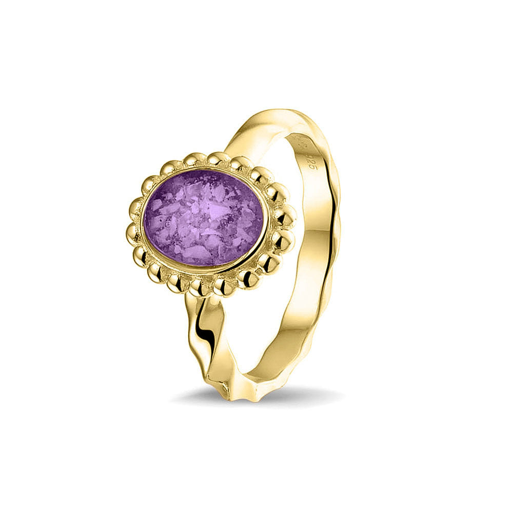 Gedenksieraad, asring met gedraaide scheen waar aan de bovenzijde in druppelvorm met parelrand zichtbaar as of haar (of eventueel melktandjes of moedermelk) verwerkt wordt. Purple