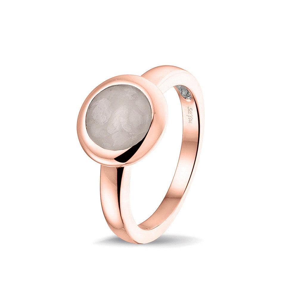 Gedenksieraad, gladde ring 3 mm waar aan de bovenzijde zichtbaar as of haar (of eventueel melktandjes of moedermelk) verwerkt wordt. Silver