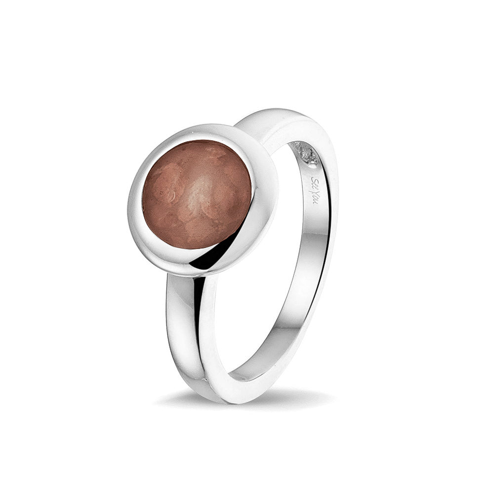 Gedenksieraad, gladde ring 3 mm waar aan de bovenzijde zichtbaar as of haar (of eventueel melktandjes of moedermelk) verwerkt wordt. Brown