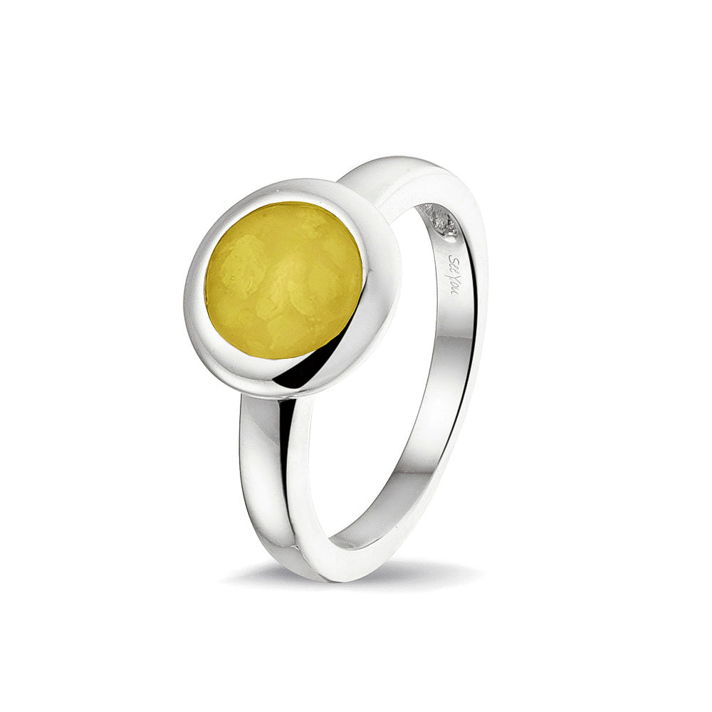 Gedenksieraad, gladde ring 3 mm waar aan de bovenzijde zichtbaar as of haar (of eventueel melktandjes of moedermelk) verwerkt wordt. Yellow