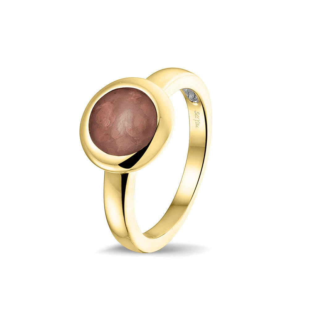 Gedenksieraad, gladde ring 3 mm waar aan de bovenzijde zichtbaar as of haar (of eventueel melktandjes of moedermelk) verwerkt wordt. Brown