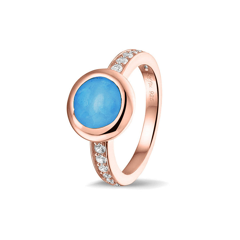 Gedenksieraad, ring 3 mm waar aan de bovenzijde zichtbaar as of haar verwerkt wordt. In de bovenste helft van de ringband zijn zirkonia's of diamanten naar keuze gezet.  Marine