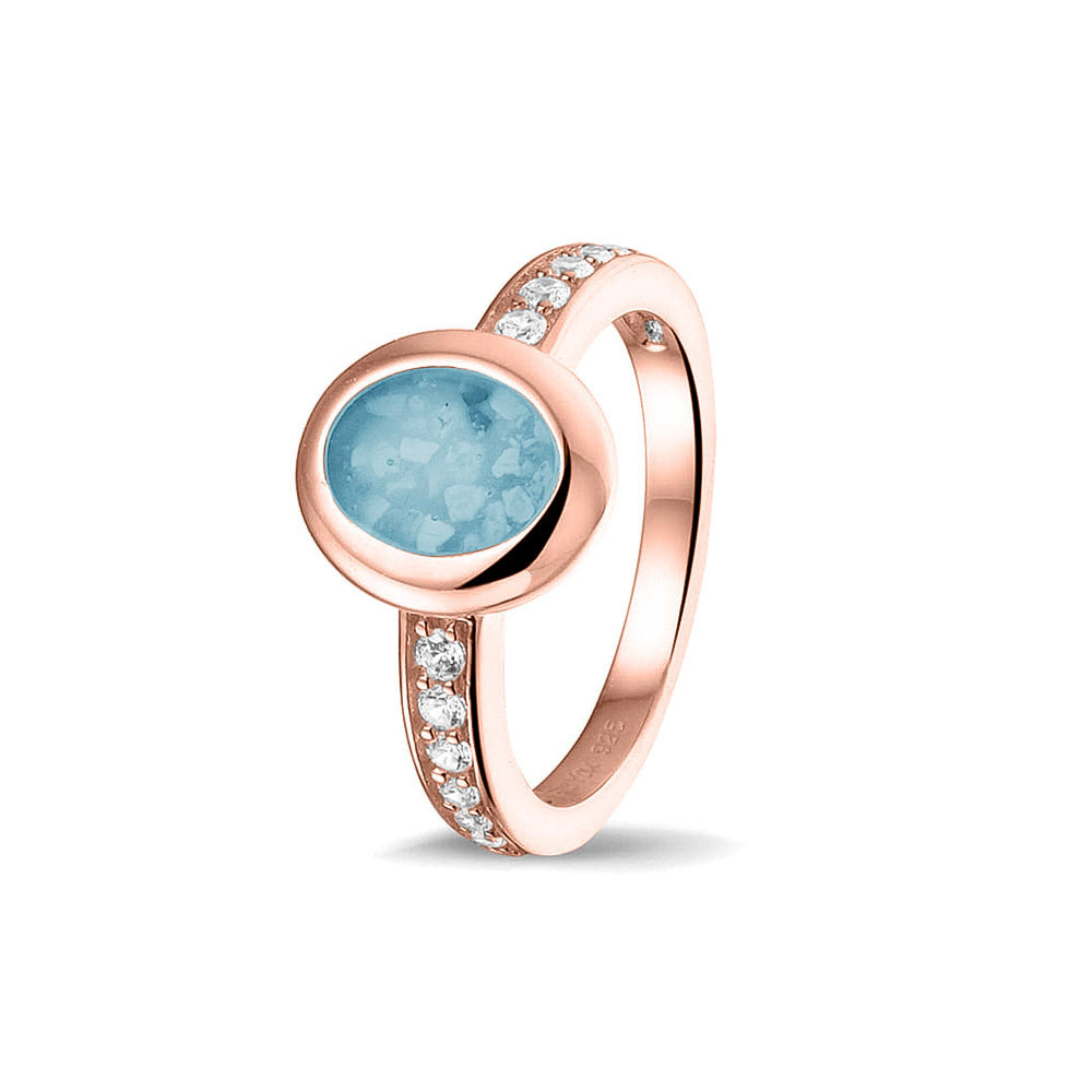 Gedenksieraad, ring 3 mm waar aan de ovale bovenzijde zichtbaar as of haar verwerkt wordt. In de bovenste helft van de ringband zijn zirkonia's of diamanten naar keuze gezet. Baby