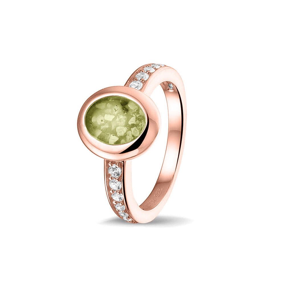 Gedenksieraad, ring 3 mm waar aan de ovale bovenzijde zichtbaar as of haar verwerkt wordt. In de bovenste helft van de ringband zijn zirkonia's of diamanten naar keuze gezet. Olive