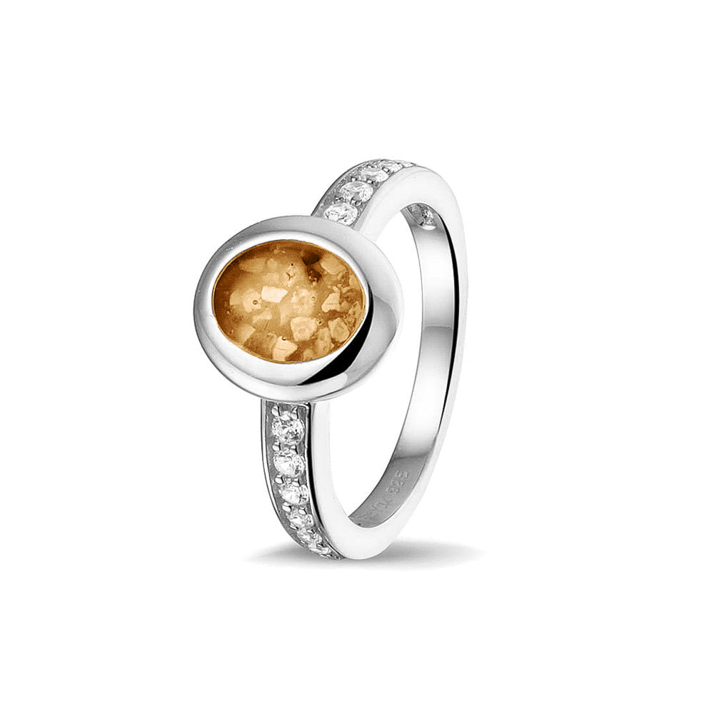 Gedenksieraad, ring 3 mm waar aan de ovale bovenzijde zichtbaar as of haar verwerkt wordt. In de bovenste helft van de ringband zijn zirkonia's of diamanten naar keuze gezet. Gold