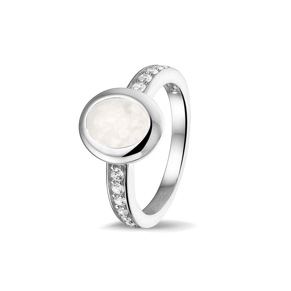 Gedenksieraad, ring 3 mm waar aan de ovale bovenzijde zichtbaar as of haar verwerkt wordt. In de bovenste helft van de ringband zijn zirkonia's of diamanten naar keuze gezet. White