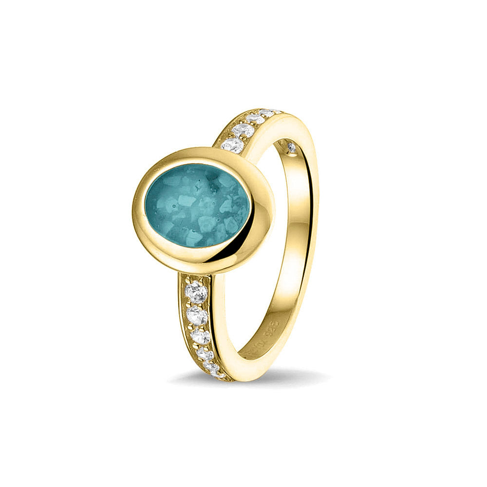 Gedenksieraad, ring 3 mm waar aan de ovale bovenzijde zichtbaar as of haar verwerkt wordt. In de bovenste helft van de ringband zijn zirkonia's of diamanten naar keuze gezet. Aqua
