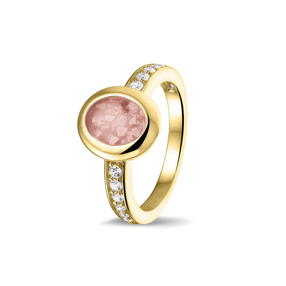 Gedenksieraad, ring 3 mm waar aan de ovale bovenzijde zichtbaar as of haar verwerkt wordt. In de bovenste helft van de ringband zijn zirkonia's of diamanten naar keuze gezet. Blush