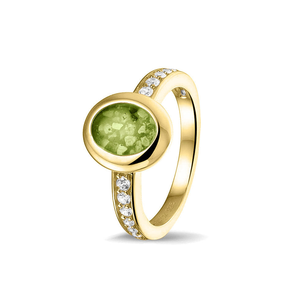 Gedenksieraad, ring 3 mm waar aan de ovale bovenzijde zichtbaar as of haar verwerkt wordt. In de bovenste helft van de ringband zijn zirkonia's of diamanten naar keuze gezet. Green