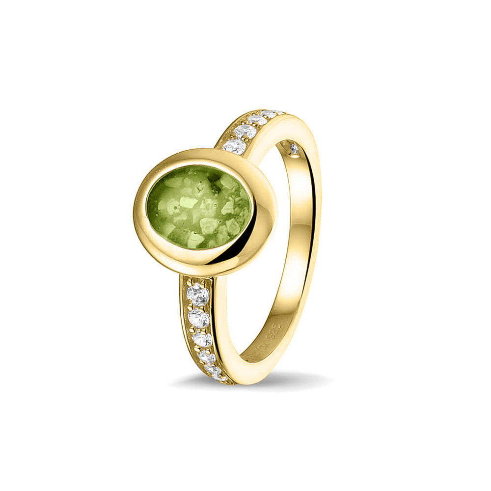 Gedenksieraad, ring 3 mm waar aan de ovale bovenzijde zichtbaar as of haar verwerkt wordt. In de bovenste helft van de ringband zijn zirkonia's of diamanten naar keuze gezet. Green