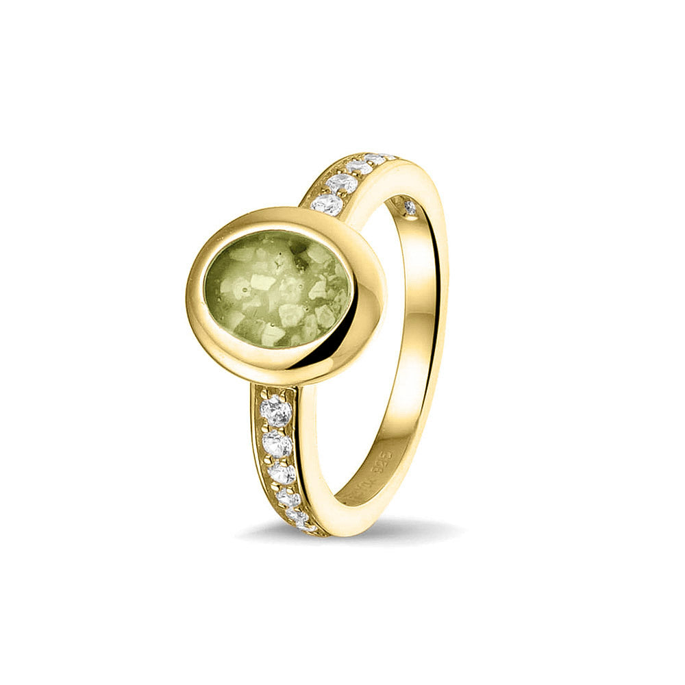 Gedenksieraad, ring 3 mm waar aan de ovale bovenzijde zichtbaar as of haar verwerkt wordt. In de bovenste helft van de ringband zijn zirkonia's of diamanten naar keuze gezet. Olive