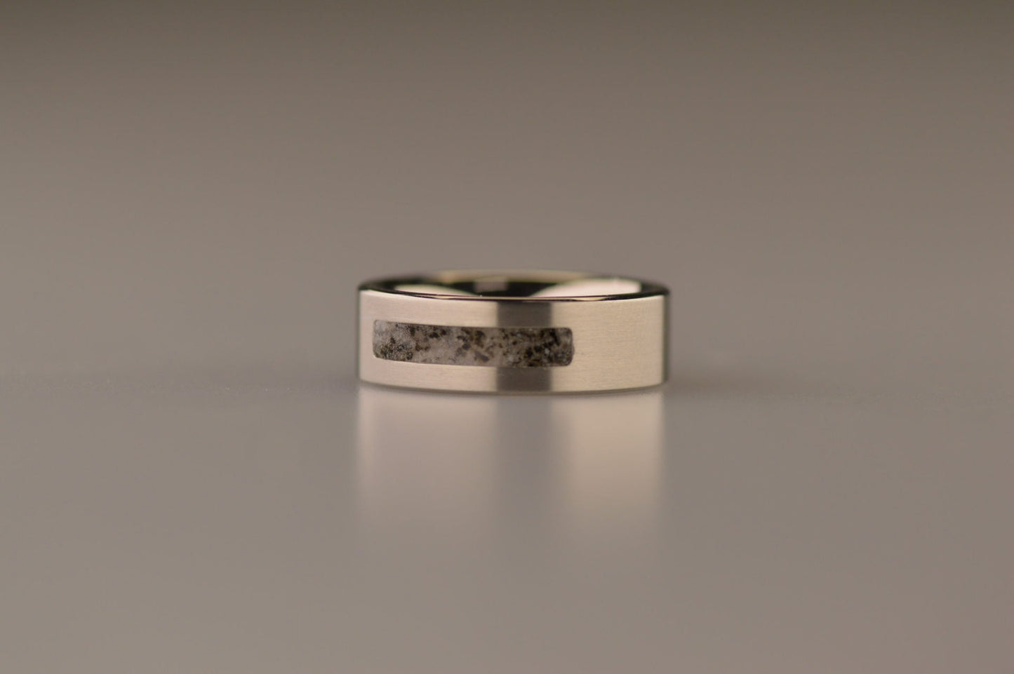 Ring als gedenksieraad 8 mm breed waar de ruimte aan de bovenzijde met as of haar verwerkt wordt. De asring is leverbaar in staal, zilver en in 14 en 18 KT geelgoud/witgoud en roségoud. Alle