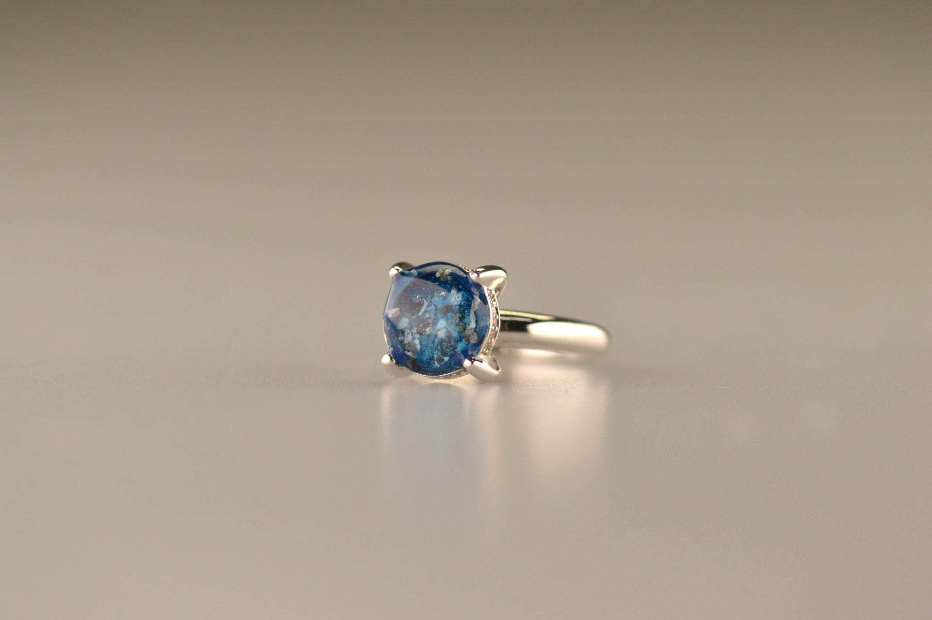 Gedenksieraad, asring 3 mm waar aan de bovenzijde zichtbaar as of haar verwerkt wordt, rondom aan de zijkant gezet met zirkonia's of diamanten naar keuze. 