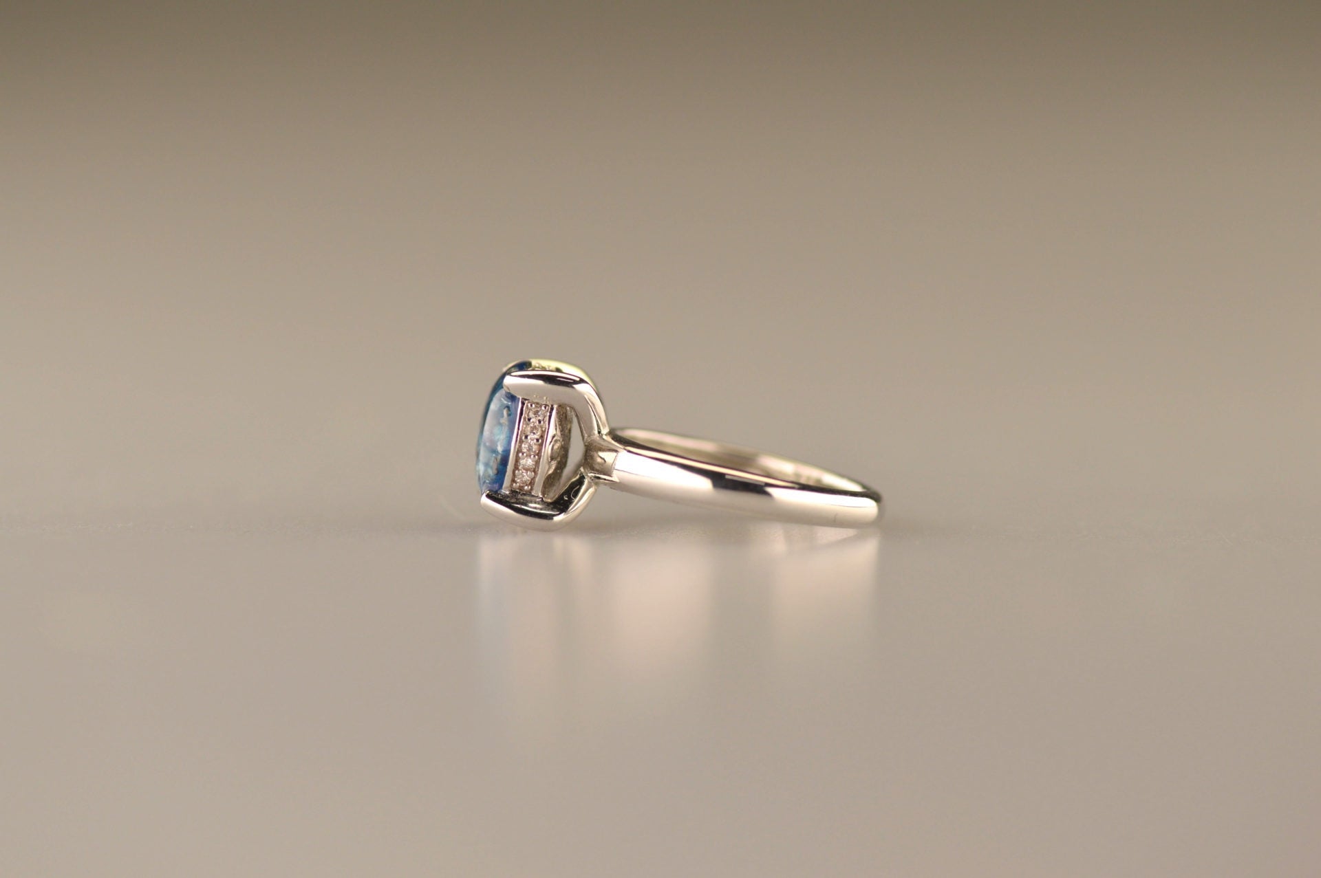 Gedenksieraad, asring 3 mm waar aan de bovenzijde zichtbaar as of haar verwerkt wordt, rondom aan de zijkant gezet met zirkonia's of diamanten naar keuze. 