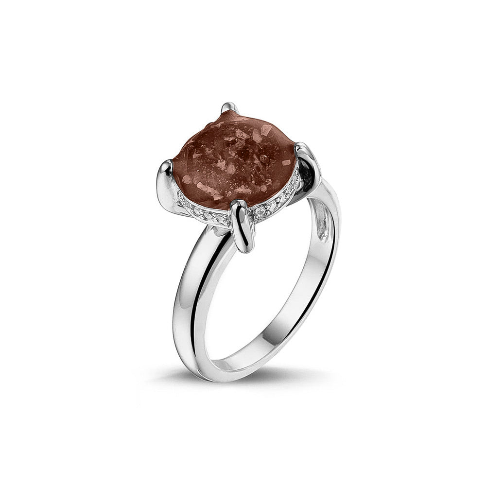 Gedenksieraad, asring 3 mm waar aan de bovenzijde zichtbaar as of haar verwerkt wordt, rondom aan de zijkant gezet met zirkonia's of diamanten naar keuze. Brown