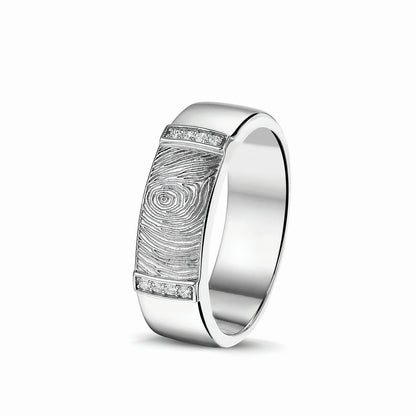 Ring 7 mm met een rechthoekig vlak aan de bovenzijde voorzien van een vingerafdruk, afgewerkt aan de randen met zirkonia's. Het is een tijdloos gedenksieraad en is te bestellen in zilver, 14 en 18 KT geelgoud,roségoud en witgoud.