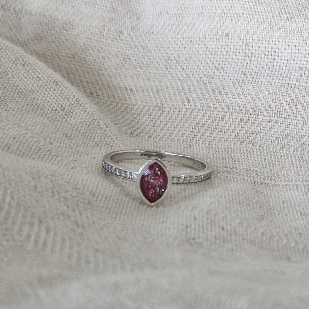 Gedenksieraad, ring 3 mm breed waar aan de bovenzijde zichtbaar as of haar verwerkt wordt. In de ringband zijn subtiel edelstenen naar keuze gezet. Alle