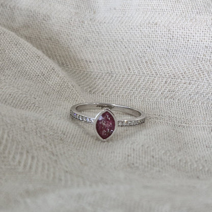 Gedenksieraad, ring 3 mm breed waar aan de bovenzijde zichtbaar as of haar verwerkt wordt. In de ringband zijn subtiel edelstenen naar keuze gezet. Alle