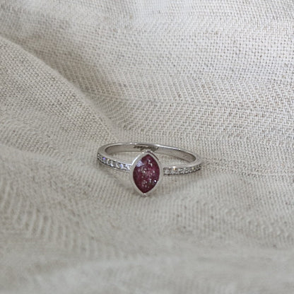 Gedenksieraad, ring 3 mm breed waar aan de bovenzijde zichtbaar as of haar verwerkt wordt. In de ringband zijn subtiel edelstenen naar keuze gezet. Alle