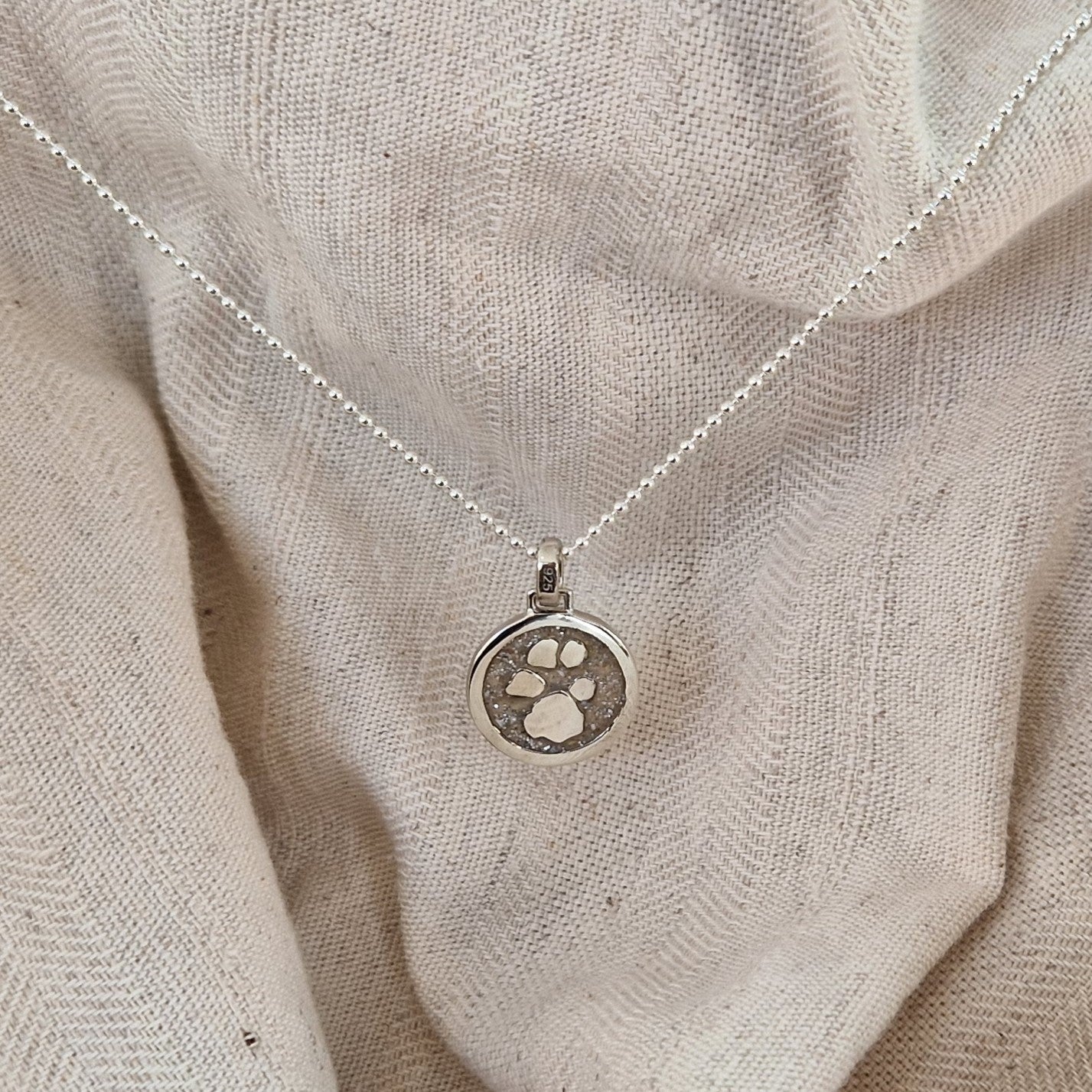 Ronde dierhanger 15 mm die zichtbaar gevuld wordt met as of haar met een aanbod van 20 kleuren, als gedenksieraad met mooie pootafdruk 