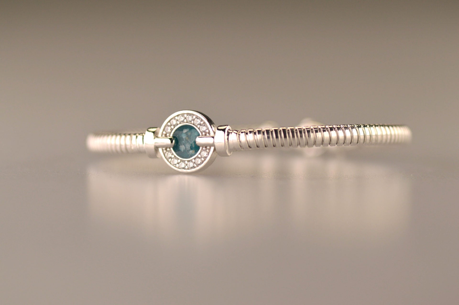 Zilveren as armband met ornamentje, dat gevuld kan worden met as.alle