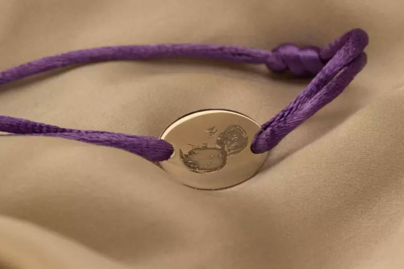 Satijnen koord armband, met ovaal graveerplaatje aan de voorzijde. Alle