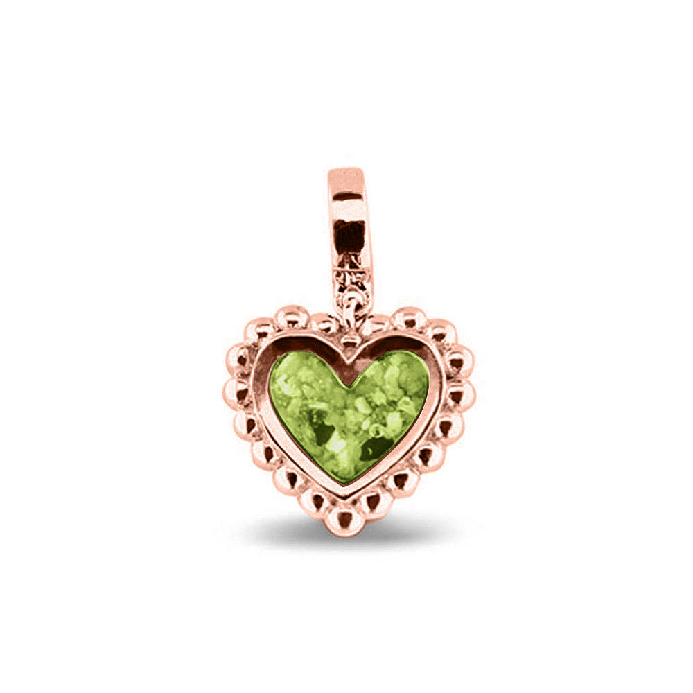 Hartvormige asbedel, die aan de voorzijde zichtbaar gevuld wordt met as of haar. Het vullen en sealen met een keuze in 20 kleuren, wordt in onze ambachtelijke edelsmederij gedaan. Green