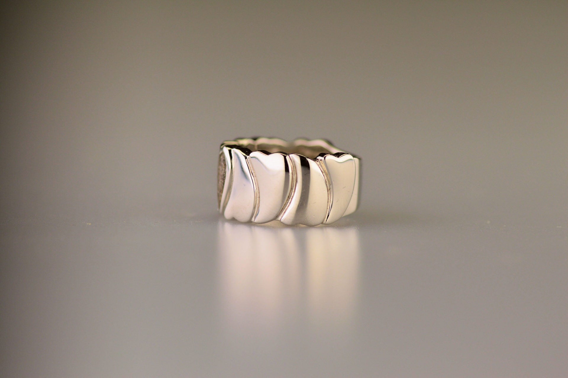 Ring 12 mm uit onze serie gedenksieraden, waar aan de bovenzijde zichtbaar as of haar (of eventueel melktandjes of moedermelk) verwerkt wordt in een hartje. 
