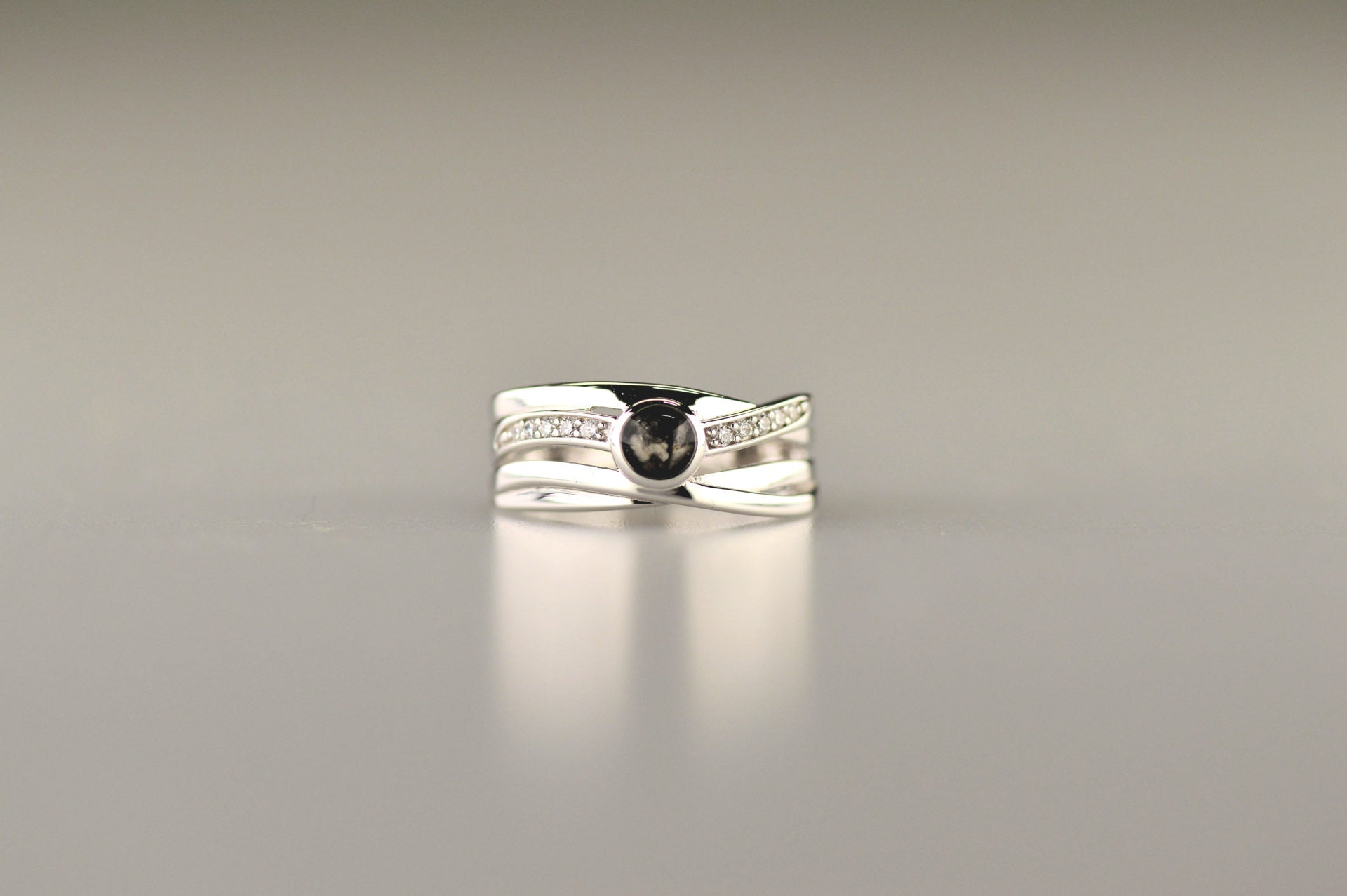 Gedenksieraad, creatieve ring 9 mm breed waar aan de bovenzijde zichtbaar as of haar verwerkt wordt in een deel van de ringband, een andere band is gezet met zirkonia's of diamanten naar keuze. alle