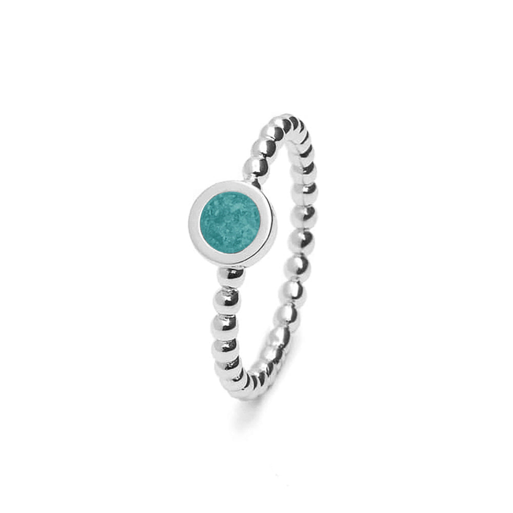 Diameter rondje: 6 mm, Ringband: 2 mm. Ring als gedenksieraad met een rondje er boven op , waar zichtbaar as of haar  in verwerkt wordt. Aqua